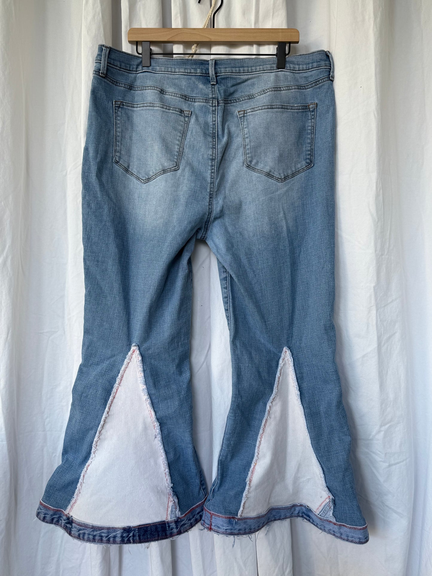 Light Wash Bell Bottom Jeans – Floral Embroidery & Raw Edge Details
